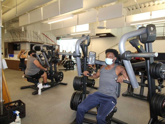 Patrons wearing masks while using workout equipment