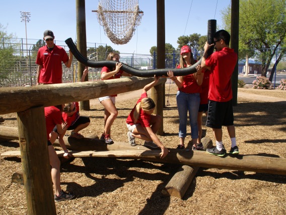 group all wearing red on the low ropes course