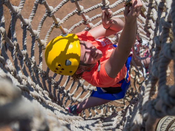 person climbing in cargo net