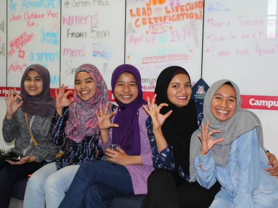 Group of students making the "c" symbol for "cats", during diversity event