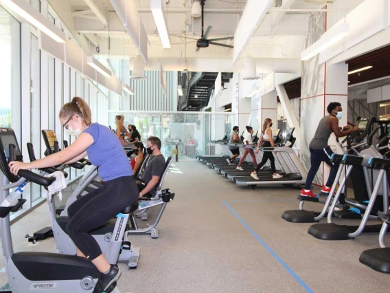 Patrons socially distanced while using bikes, ellipticals, and treadmills