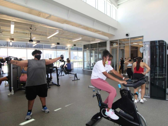 Patrons socially distance working out on machines and with free weights