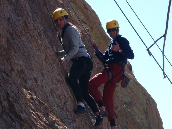 Two climbers giving thumbs up for photo while climbing
