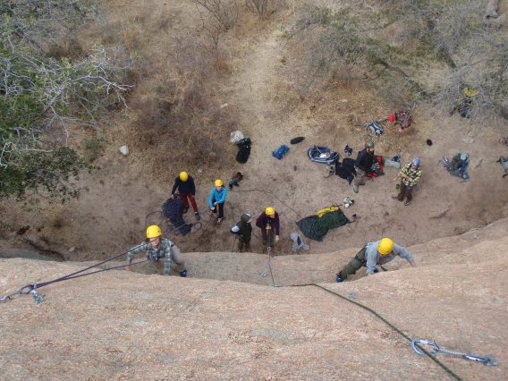 Birds-eye view of climbers from the top of the cliff, looking down