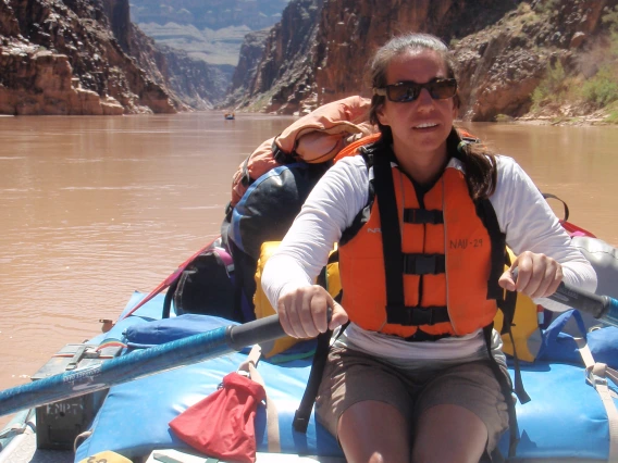 Canoer paddling through a river in a canyon