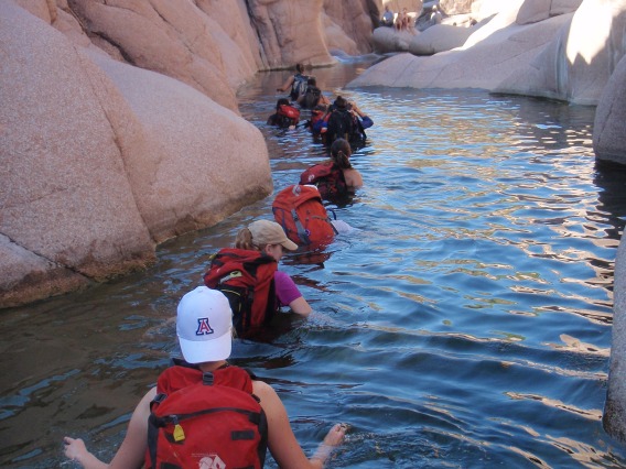 Group of canyoneers wading through chest deep water in Salome Jug canyon