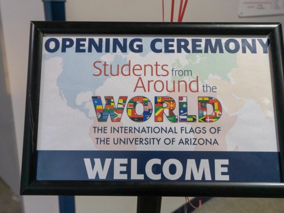 Sign reads: Opening ceremony, Students from Around the Worls, The International Flags of The University of Arizona. Welcome.
