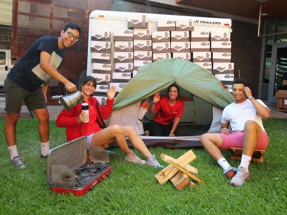 Campus Rec student employees sitting in a fake campsite at Campus Rec