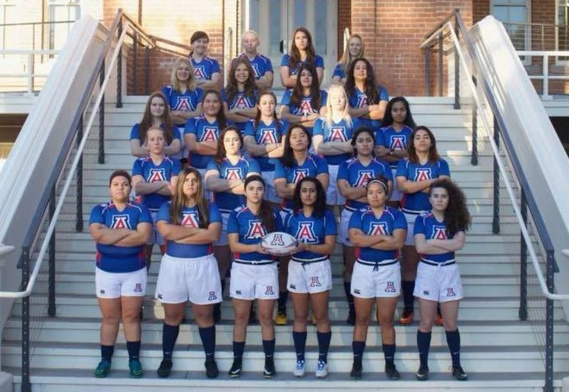 Women's Rugby team standing on Old Main steps for team photo, with arms crossed