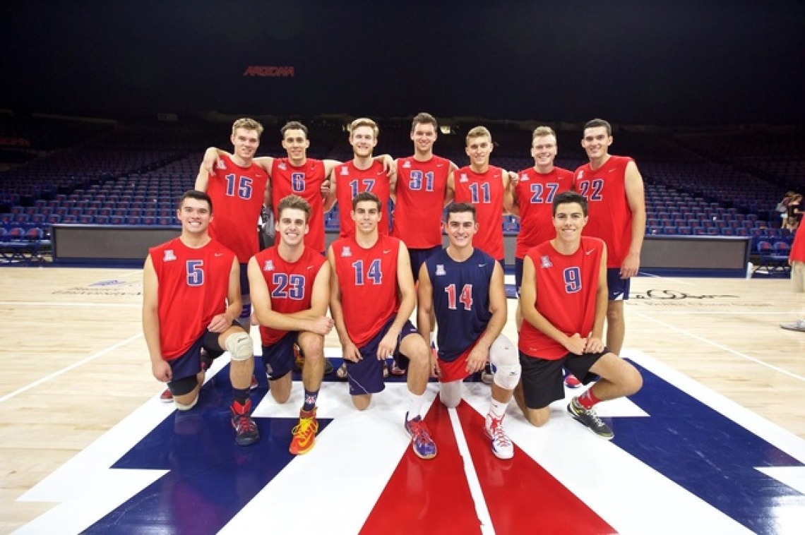 Men's volleyball team posing for team photo on UArizona court