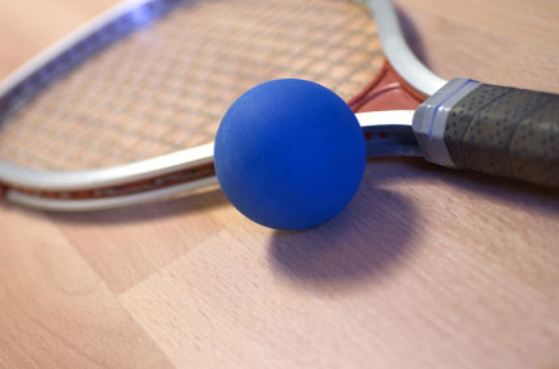 Blue ball sitting next to racquetball racquet