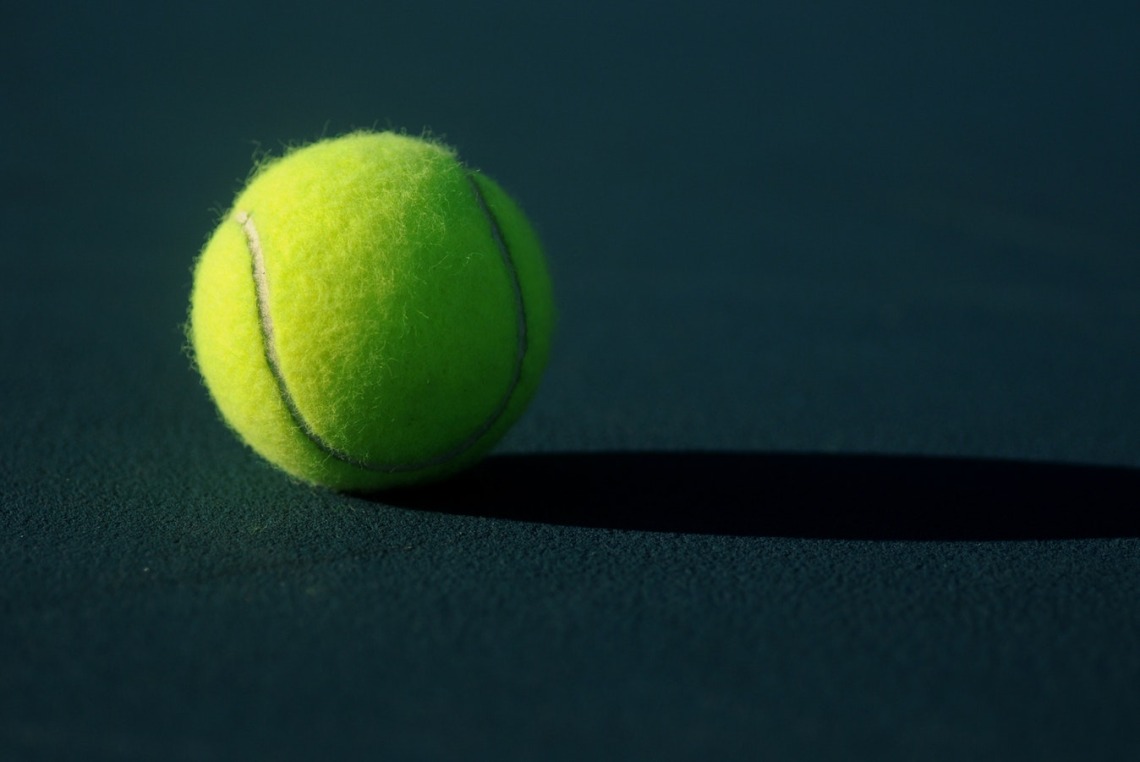 Tennis ball sitting on court floor