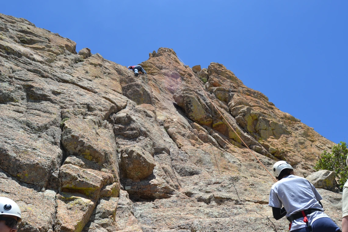 Group of climbers scaling up a rock cliff