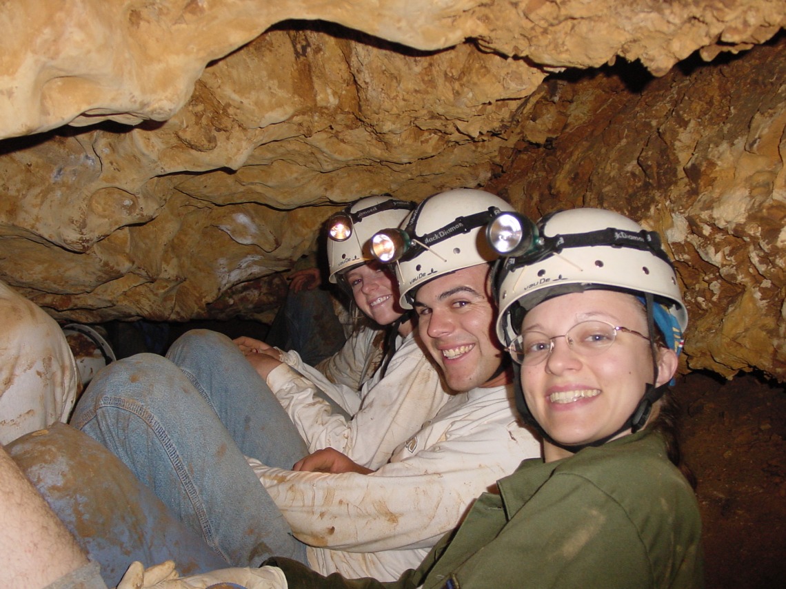 Group of spelunkers smiling for photo in a tight space