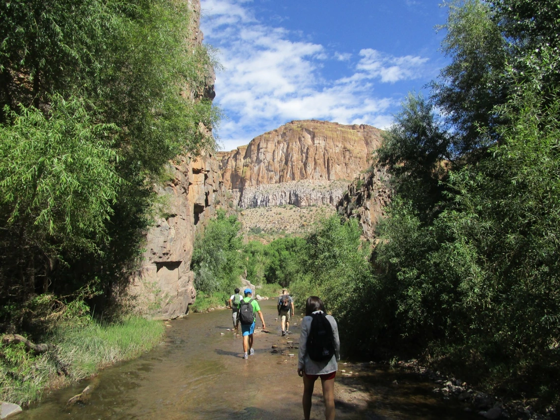 Group of hiking walking through a stream