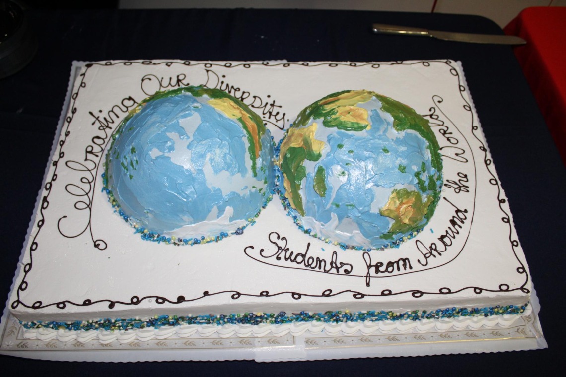 Cake with both halves of the globe, frosting reads: Celebrating our Diversity, students from around the world