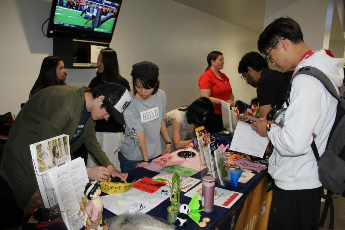 Group of students at informational booth at Campus Rec during diversity event