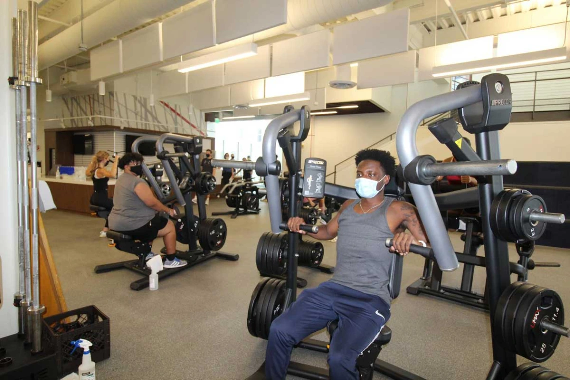 Patrons wearing masks while using workout equipment