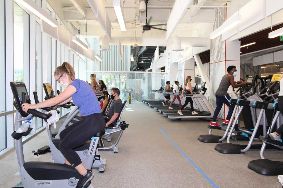 Patrons socially distanced while using bikes, ellipticals, and treadmills