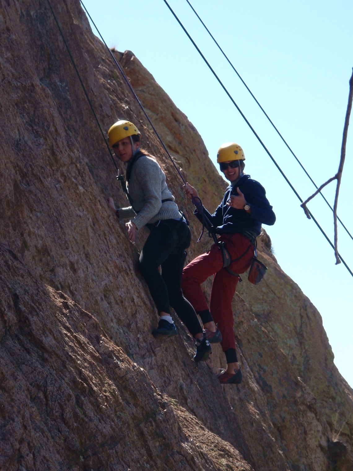 Two climbers giving thumbs up for photo while climbing