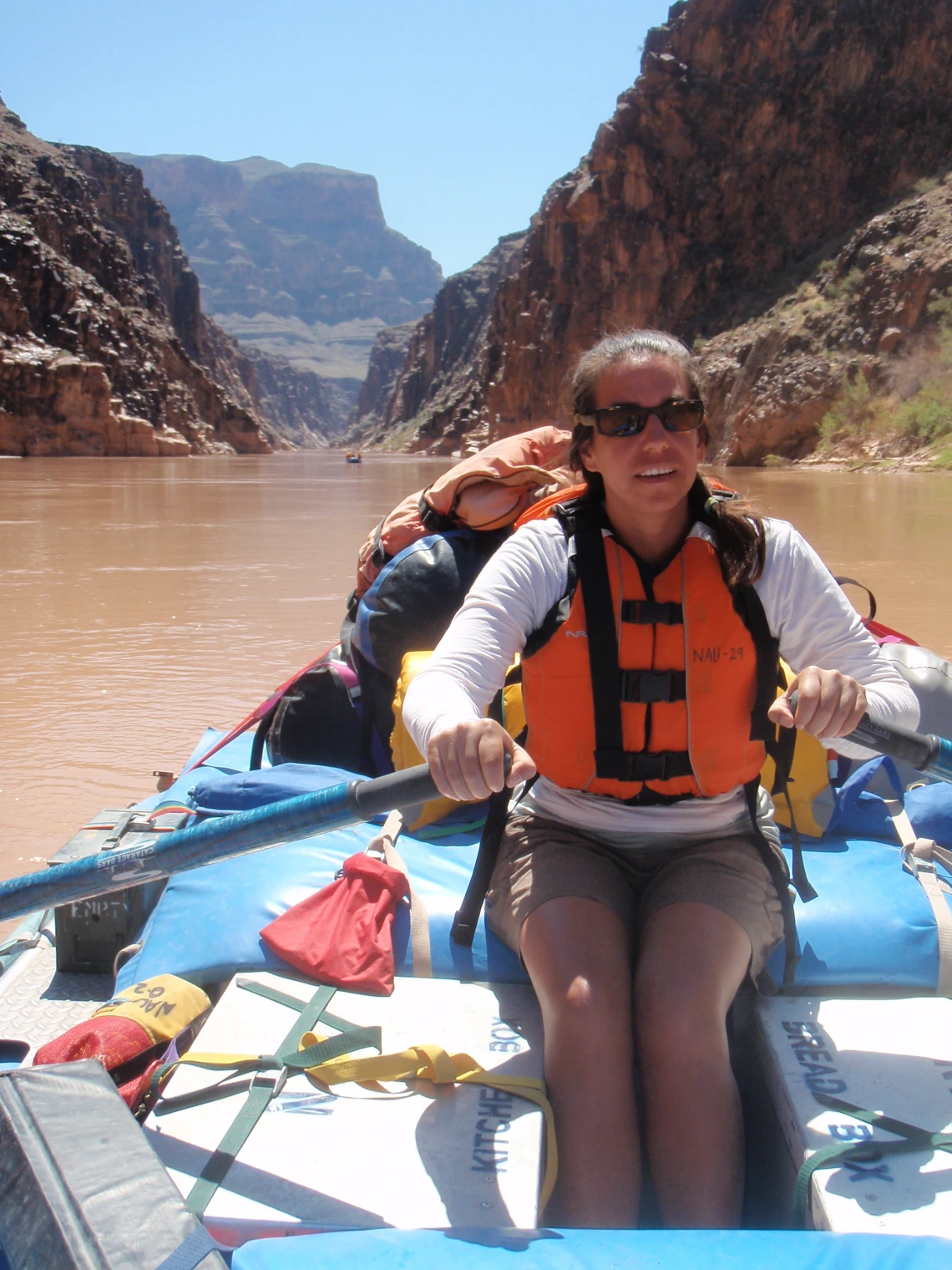 Canoer paddling through a river in a canyon