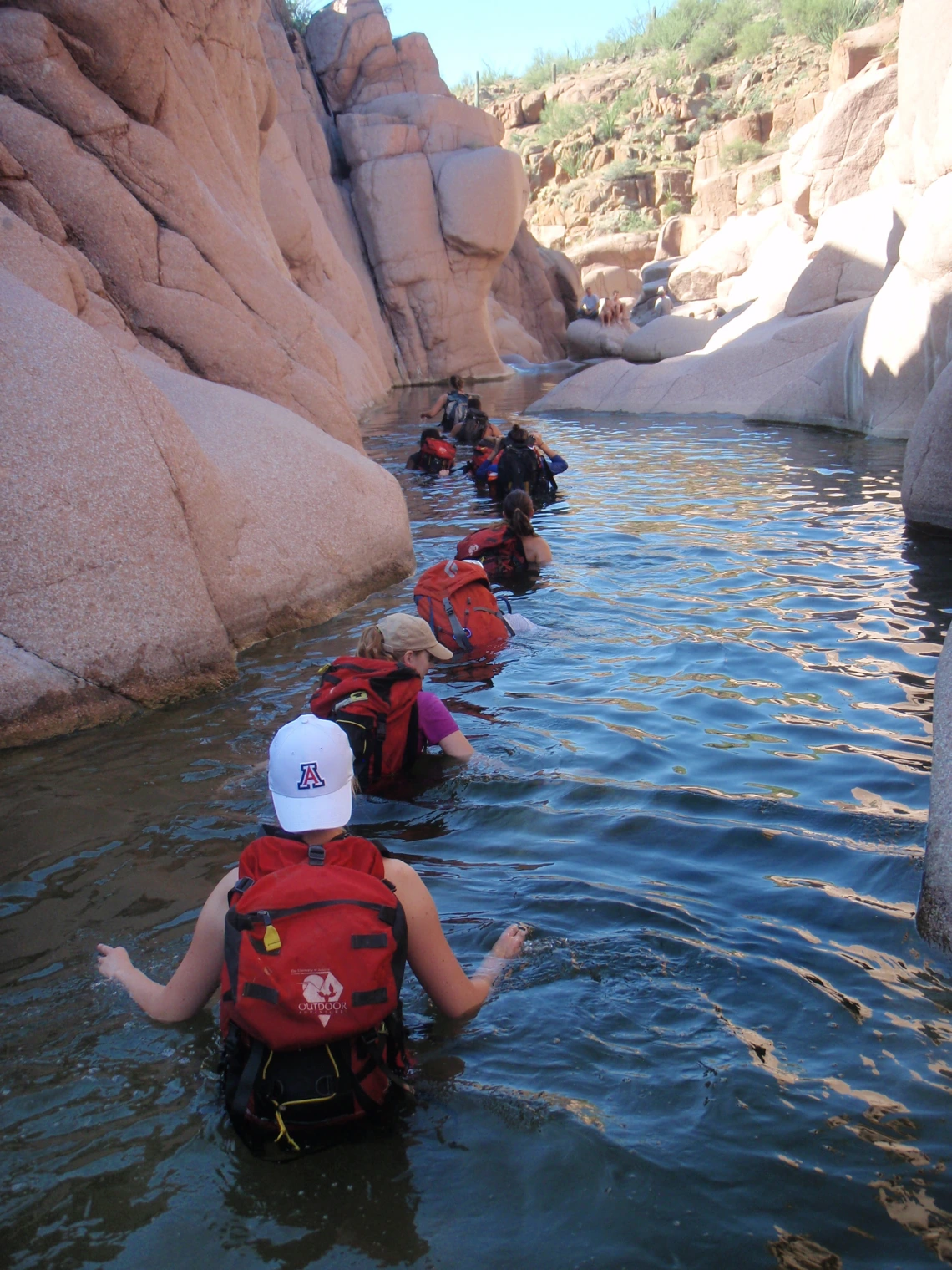 Group of canyoneers wading through chest deep water in Salome Jug canyon