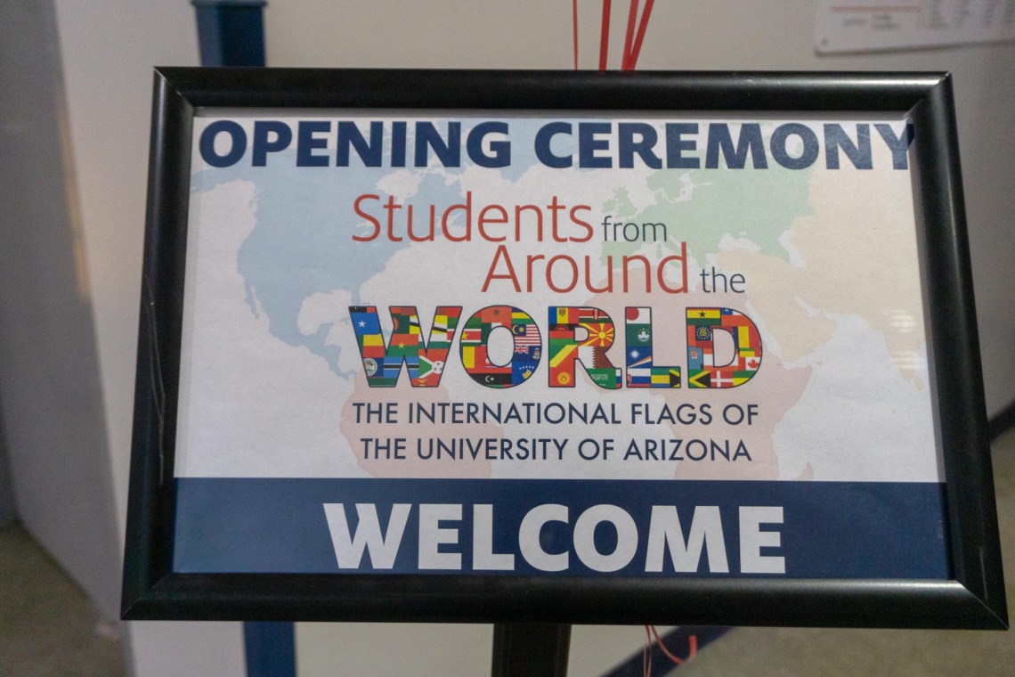 Sign reads: Opening ceremony, Students from Around the Worls, The International Flags of The University of Arizona. Welcome.