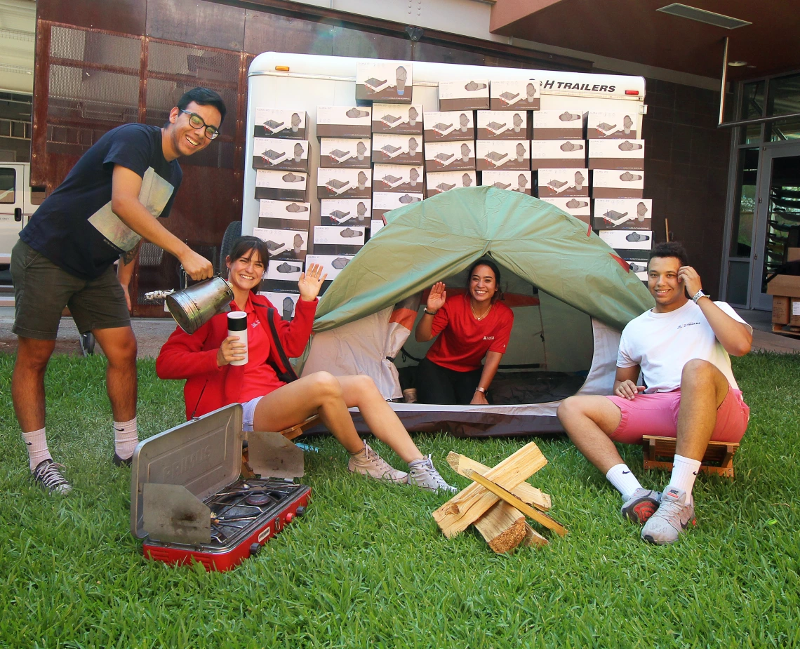 Campus Rec student employees sitting in a fake campsite at Campus Rec