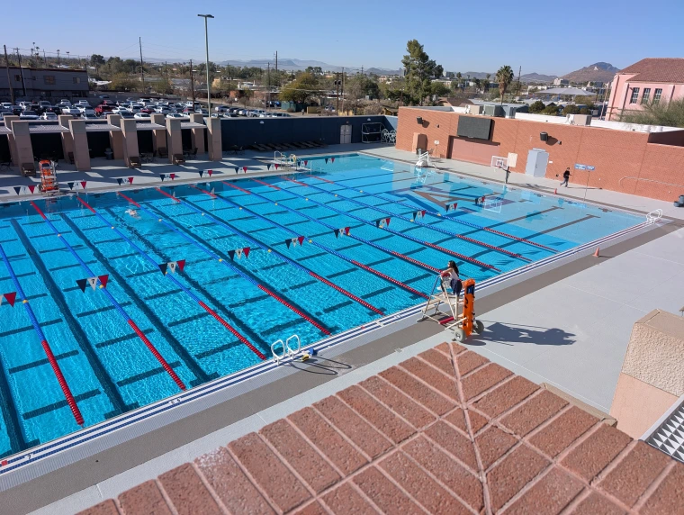 Overhead view of swimming pool with female lifeguard in stand.