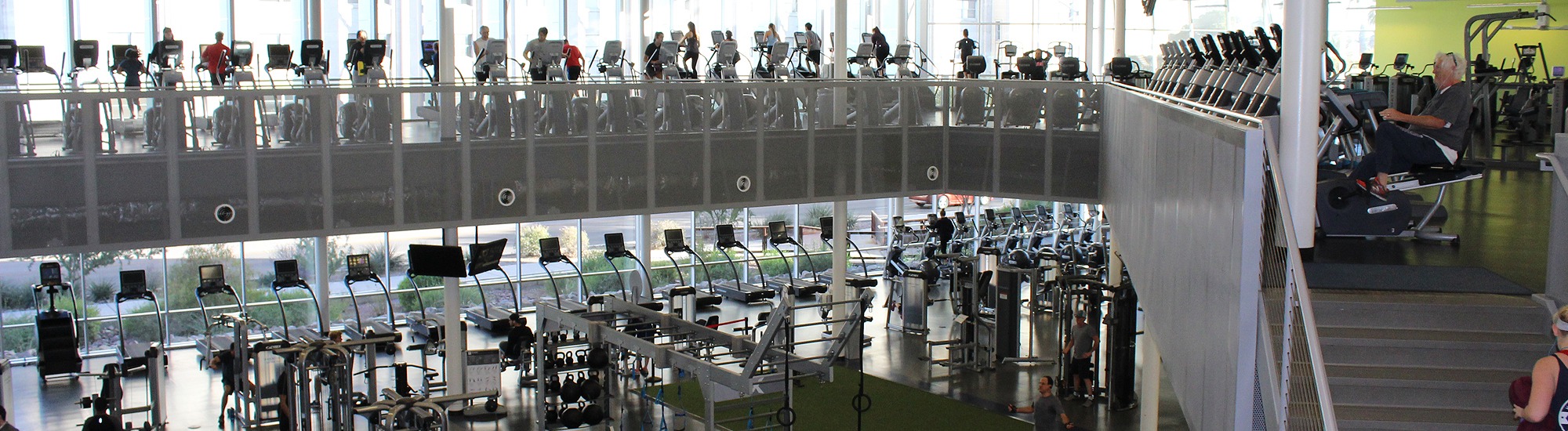 Second floor view of the Fitness Center, treadmills, ehlipticals and spinners being used