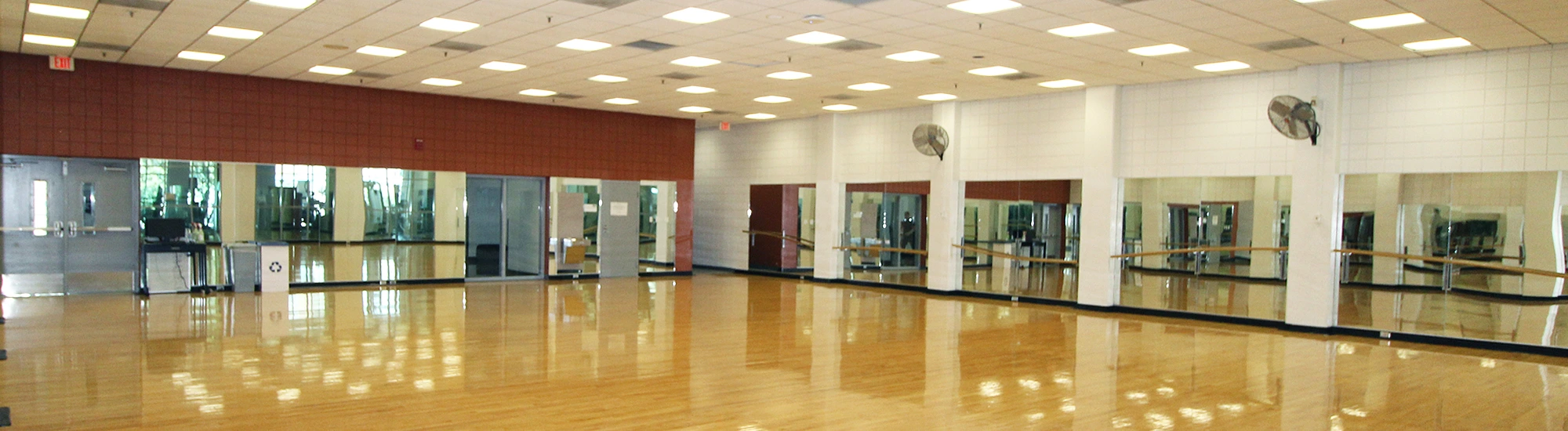 Multipurpose room with hardwood floors and mirrors on every wall