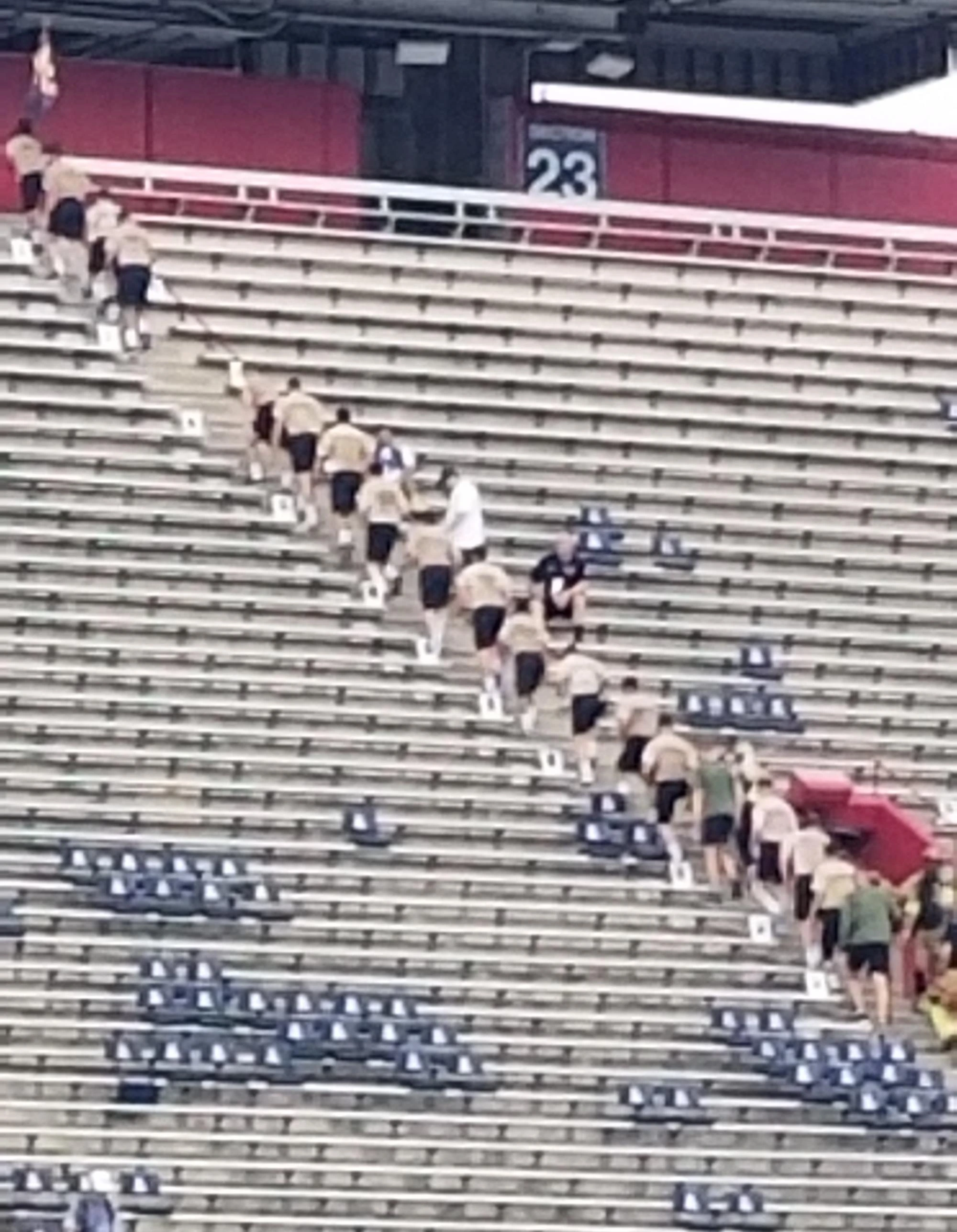 Group of personnel in matching shirts climbing stairs