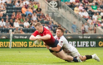 Rugby player tackling another player carrying the football